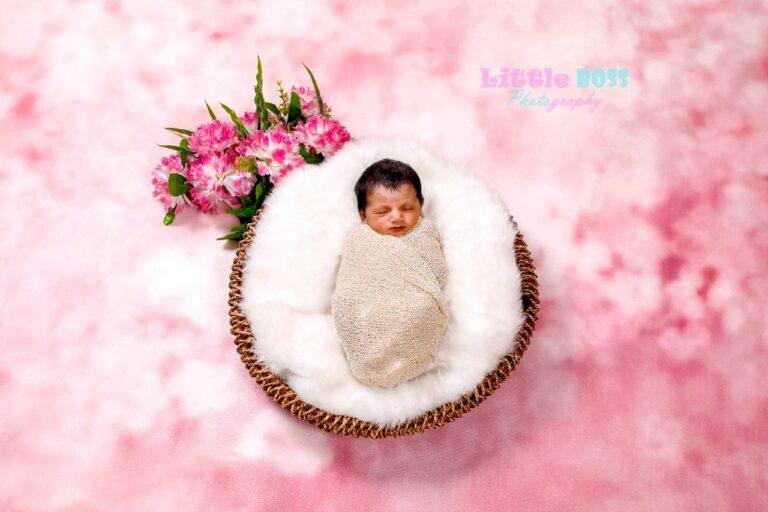 In a wooden basket baby wrapped with half white wrapper