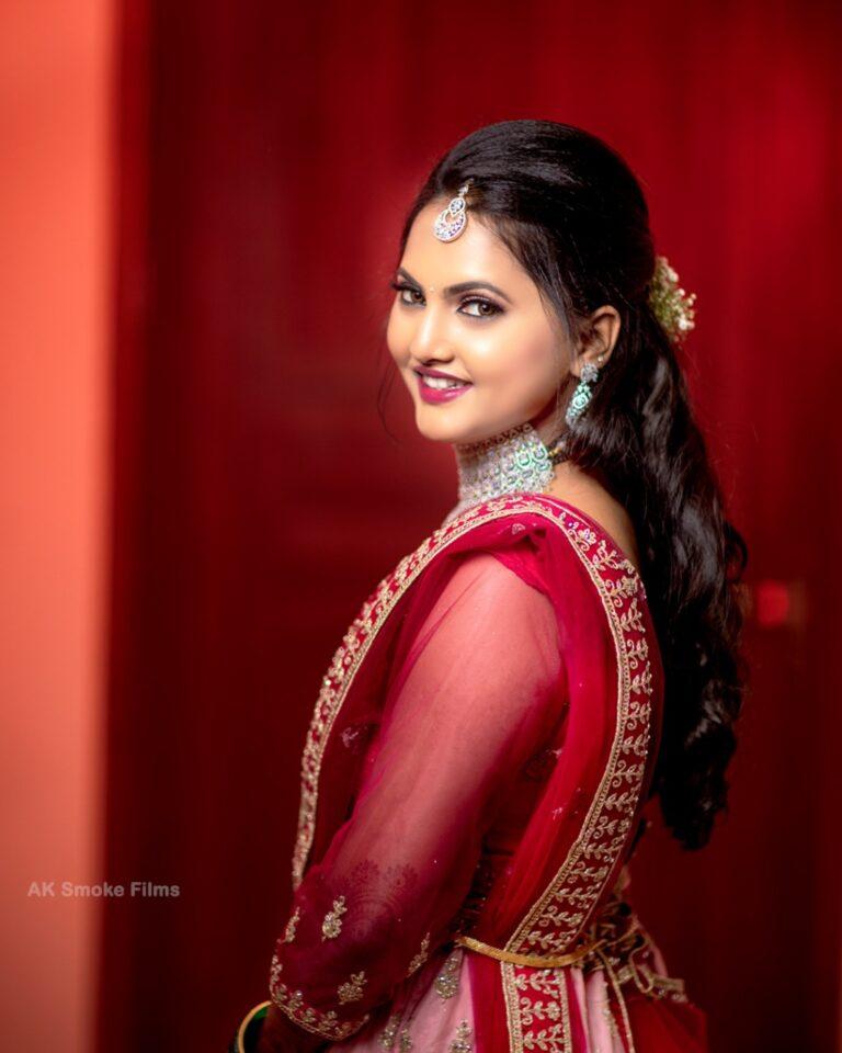 Bride in red reception attire turning towards camera smiling